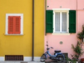 Motorcycle in front of colouful painted houses in gargnano, Italy