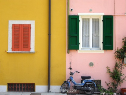 Motorcycle in front of colouful painted houses in gargnano, Italy